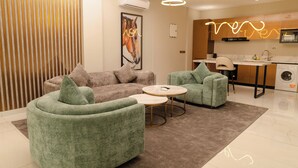 A modern living room with a sofa, two armchairs, and a coffee table. - Sterling Suites (Accra)