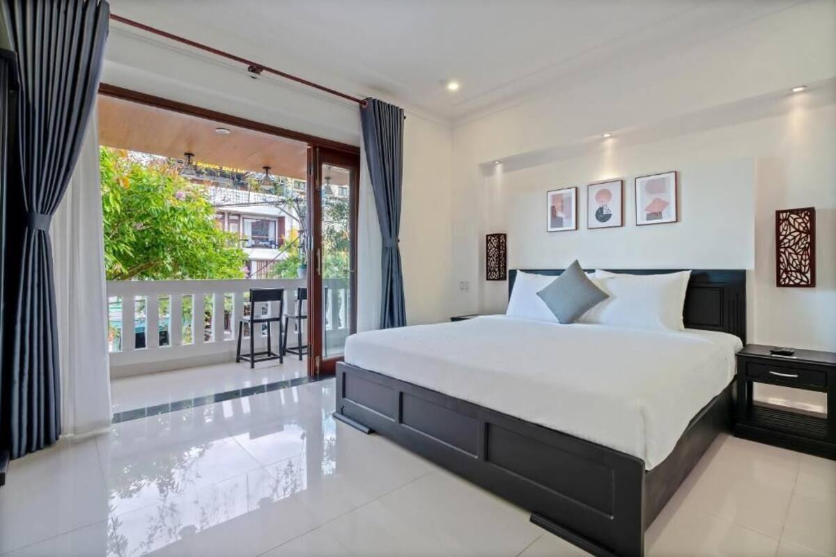 Une chambre spacieuse avec un grand lit, un balcon offrant une belle vue et un design moderne.