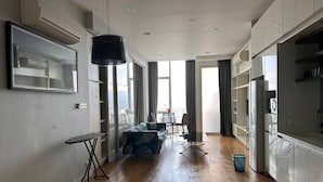Una cocina moderna con armarios blancos, un comedor con mesa y sillas, y un sofá.