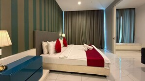 Una habitación de hotel moderna con una cama grande, una mesita de noche y vistas al pasillo.