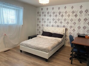 Ein Schlafzimmer mit einem Bett, einem Schreibtisch und einem Stuhl.