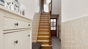 A narrow hallway with a wooden staircase leading to a door at the end. - Beautiful room (Molenbeek-Saint-Jean)