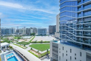 A modern high-rise building with a rooftop pool and landscaped areas. - Bloomfields 2BR-Marquis 2020-Arjan (Dubai)