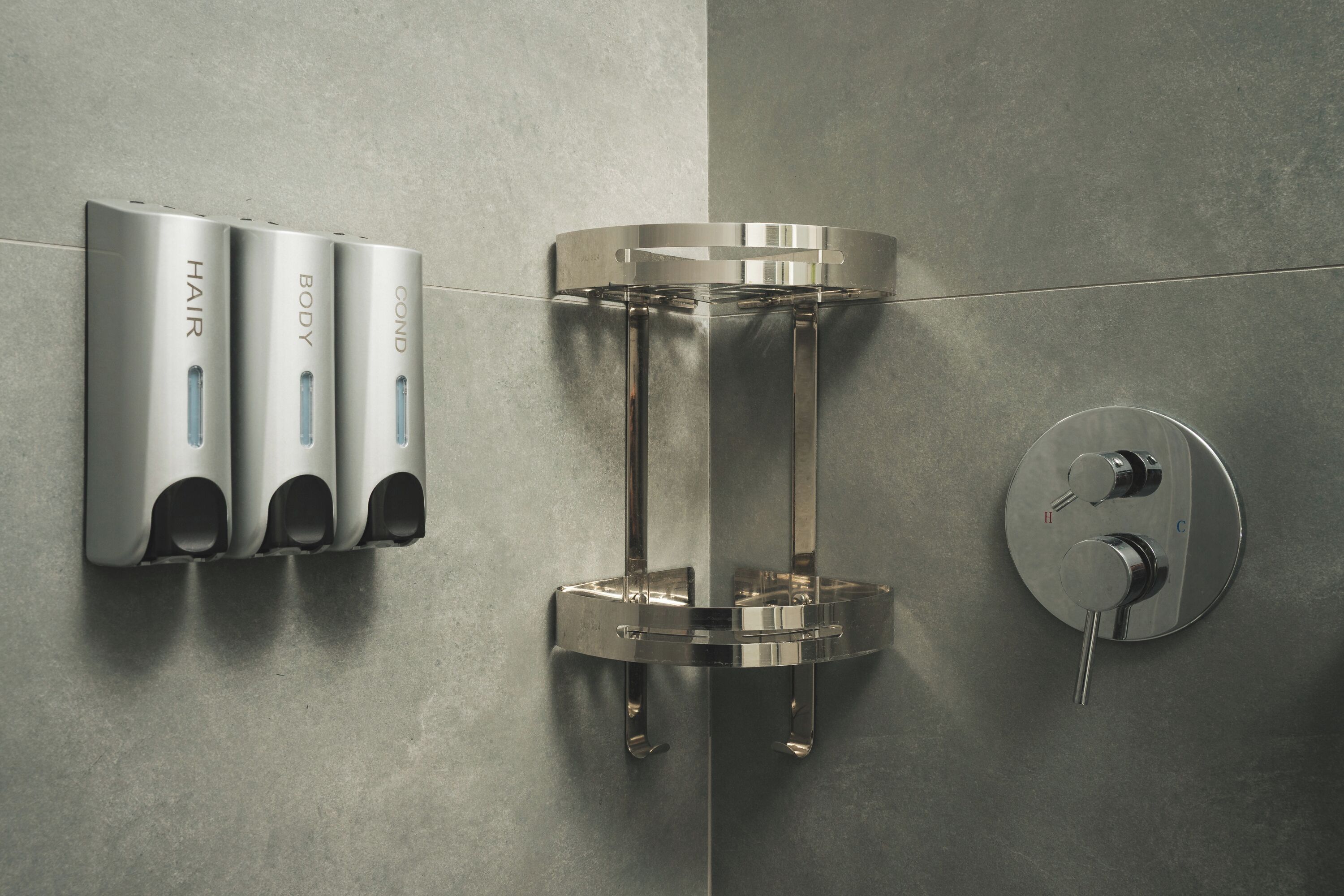 Un baño moderno con un secador de manos en la pared, un dispensador de toallas y un grifo.