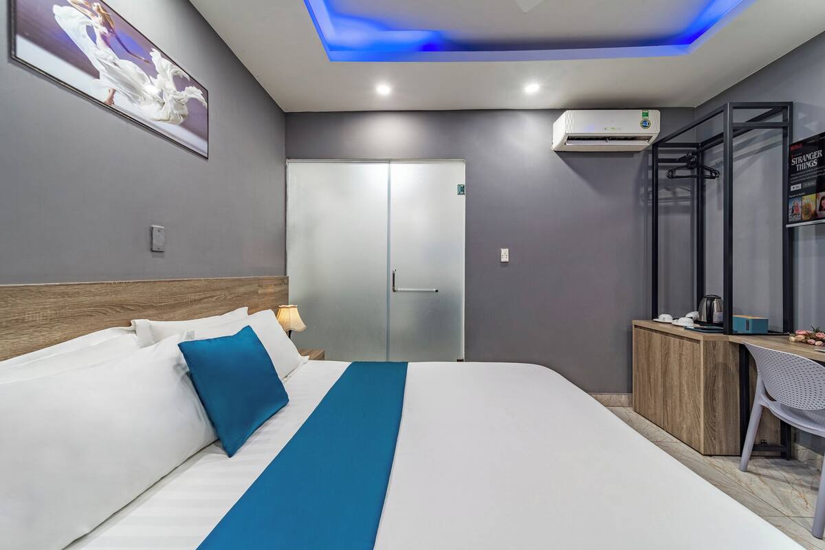 Ein modernes Hotelzimmer mit Bett, Schreibtisch und Kleiderschrank.