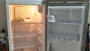 An open refrigerator with multiple shelves and a freezer compartment. - Ground floor one-bedroom apartment in a condominium with swimming pools and 100 meters from the sea in Florianópolis, SC. (Florianópolis)