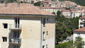 Un pueblo en la ladera de una colina con edificios, incluyendo un edificio blanco destacado con un campanario.