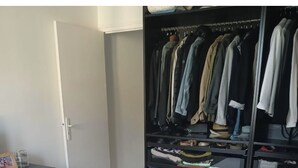 Un dormitorio con cama, armario y cómoda.