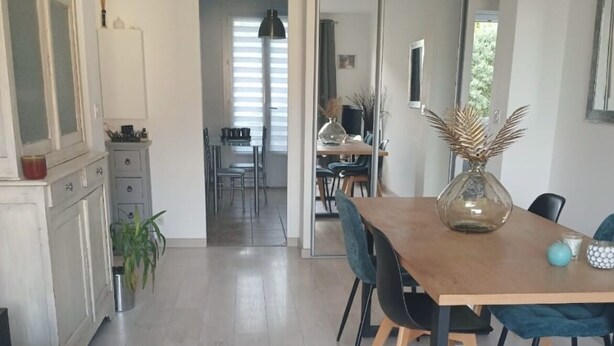 Una sala moderna con comedor, cocina y pasillo que conduce a un salón de comidas.