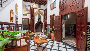 Ein traditionelles Interieur mit Treppe, Holztüren und Fliesenboden.