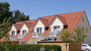 En række moderne huse med røde tegltage og altaner.