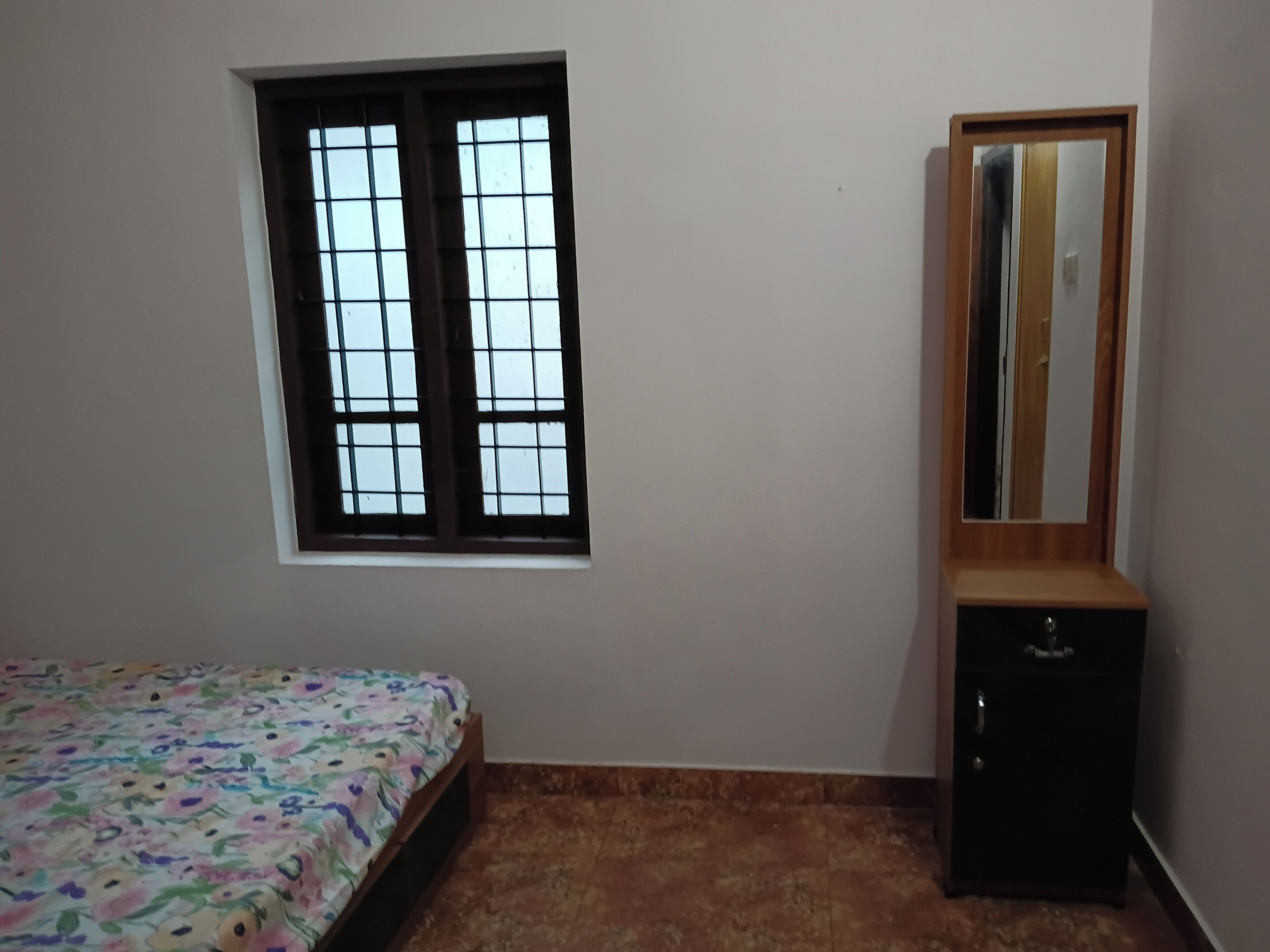 Un dormitorio con cama, ventana, armario y espejo.