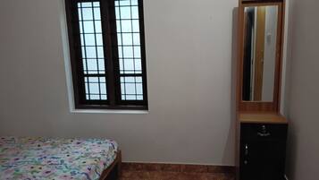 Un dormitorio con cama, ventana, armario y espejo.
