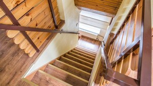 Una escalera de madera con barandillas de metal y piso de madera.