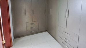 Una habitación con un armario grande, una puerta y suelo de baldosas.