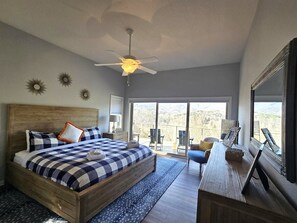 A bedroom with a large bed, a desk, and a balcony with a view. - Cloud 10 at Rumbling Bald (Lake Lure)