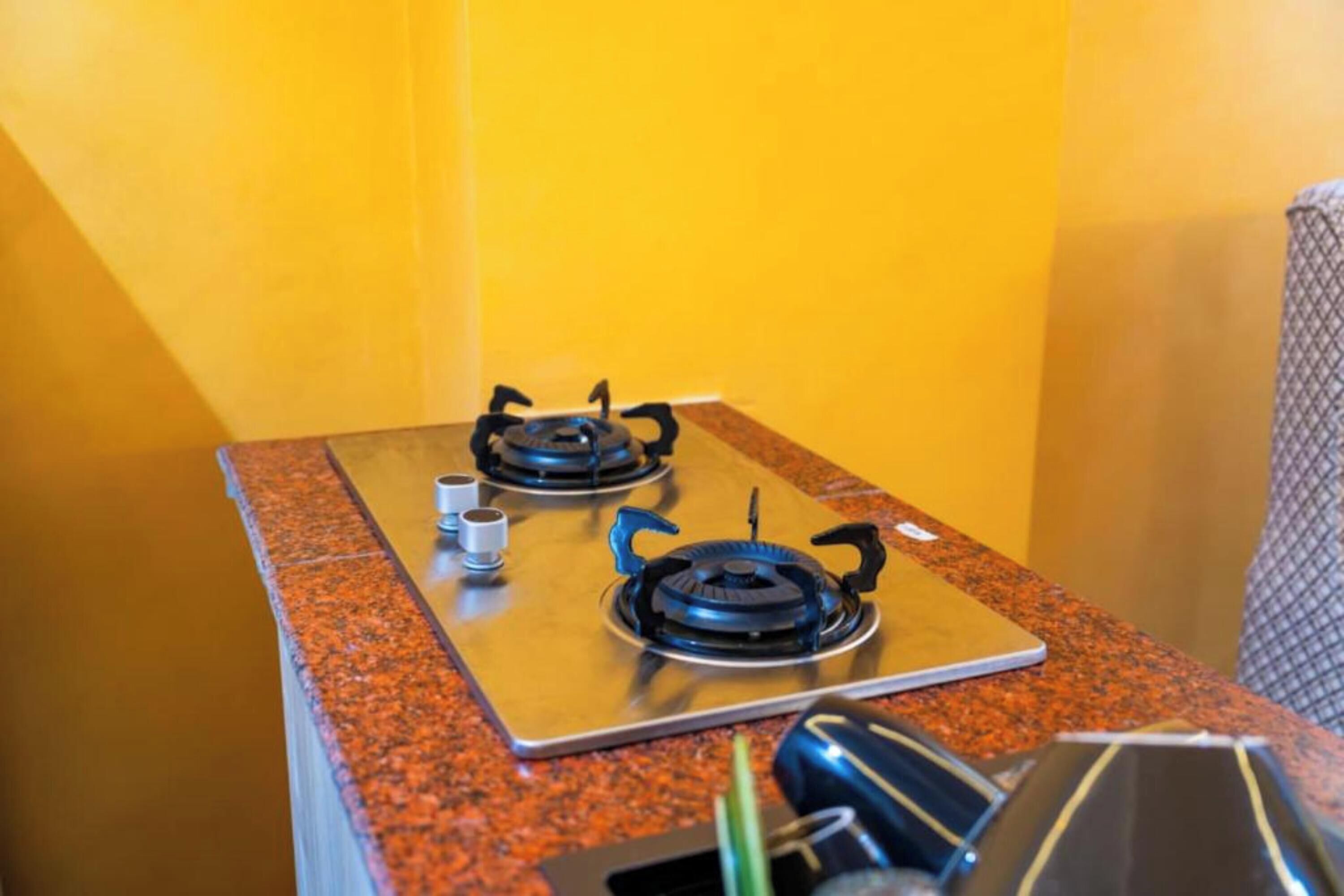 A kitchen with two gas stoves on a granite countertop.