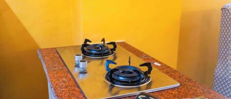 A kitchen with two gas stoves on a granite countertop.