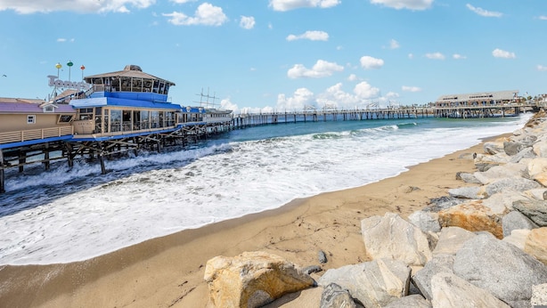 Ein Küstenhotel mit einer Pier, die sich ins Meer erstreckt, mit Restaurant und Bar.