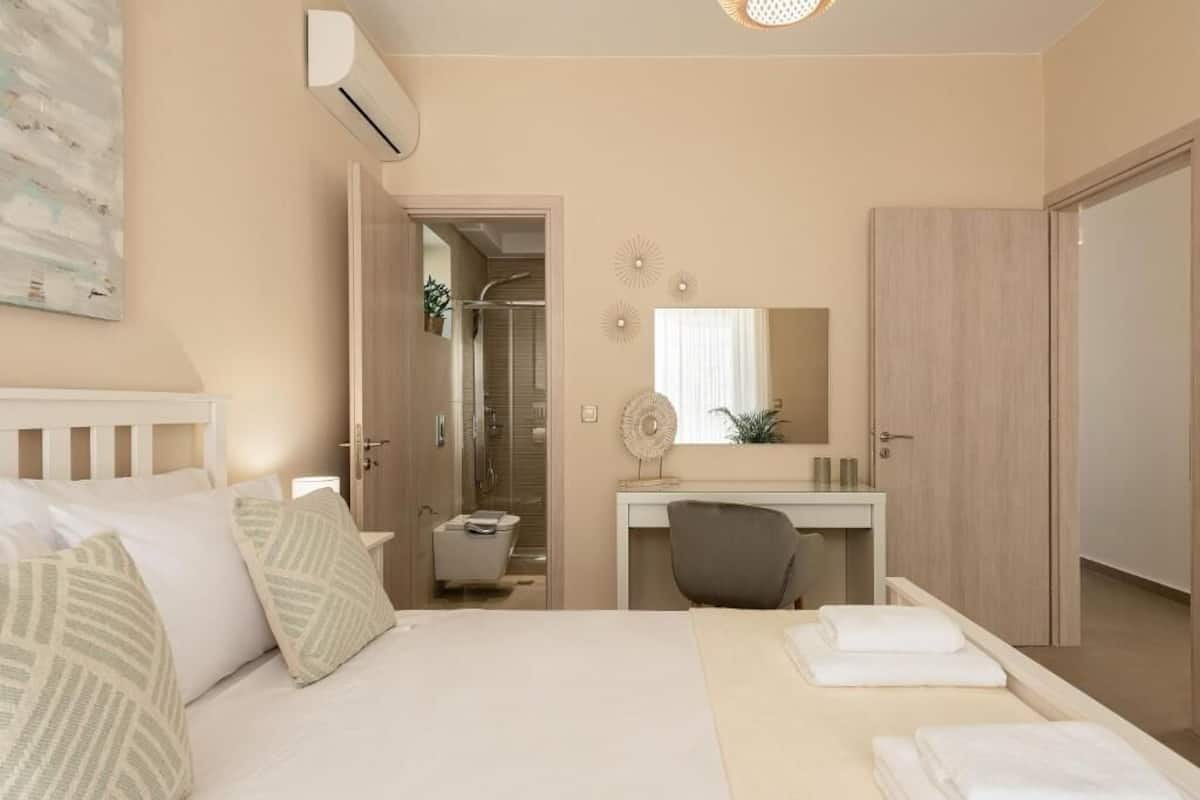 A bedroom with a bed, bedside table, and a desk with a chair.