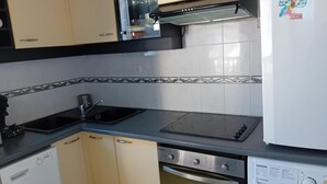 A compact kitchen with a sink, stove, and built-in oven. There is a washing machine and a refrigerator. - Seignosse Penon - T2 Atlantic Coast Near Beach (Seignosse)