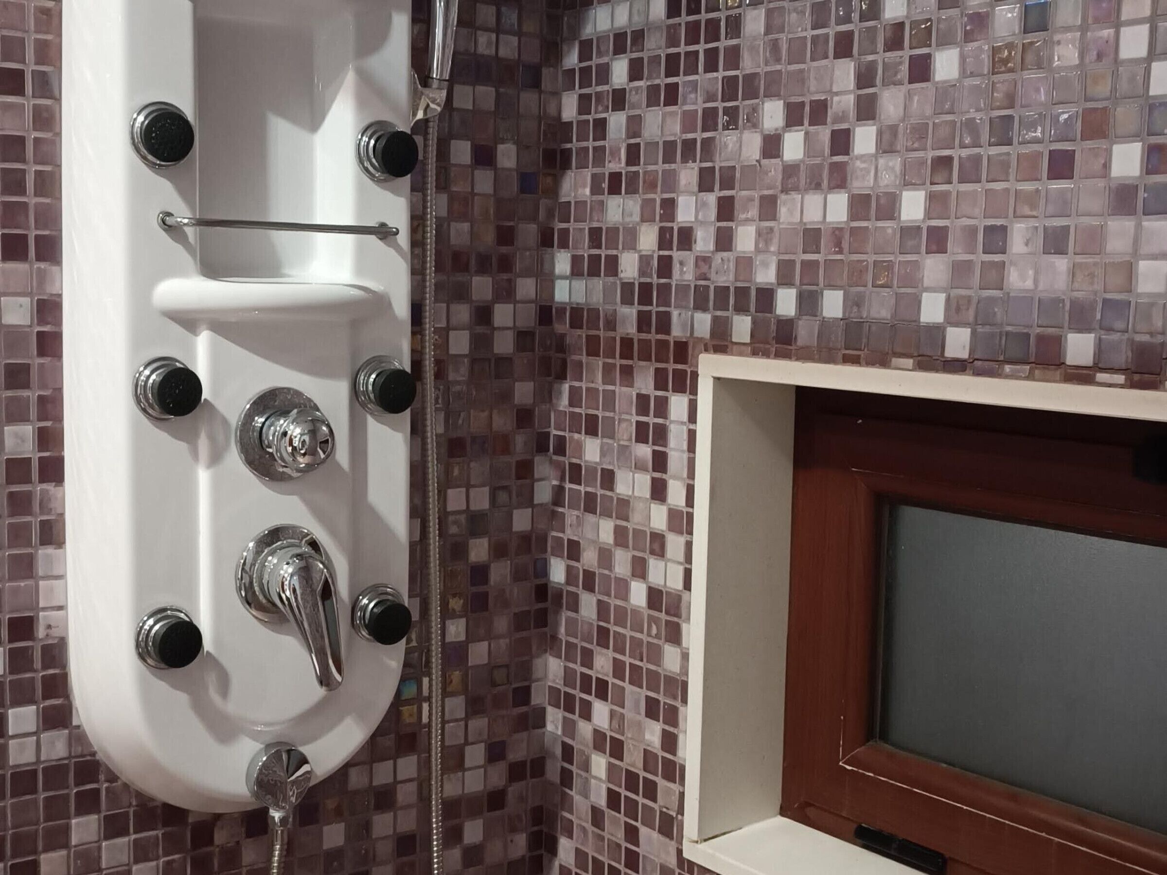 Ein Badezimmer mit Dusche, Waschbecken und Spiegel.