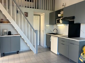 A compact kitchen with a built-in dishwasher, a microwave, and a sink. - Villa 6 pers Aircon - Direct Beach Access - Pool (Gruissan)