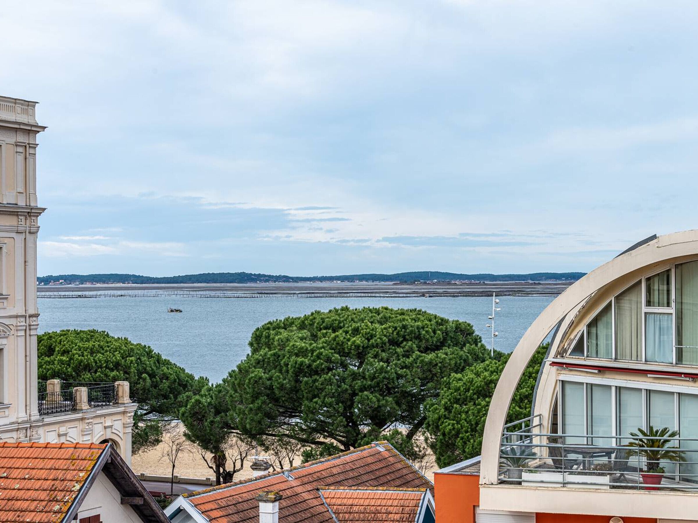 Une vue sur la côte, avec un bâtiment doté d’un balcon incurvé donnant sur la mer.