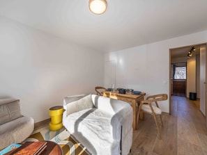 A cozy living room with a sofa, a coffee table, and a dining area with a table and chairs. - Charming property in Méribel (Méribel)