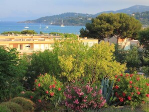 A coastal view with a building, trees, and a clear sky. - 2-room apartment with terrace near the beach (Bormes-les-Mimosas)