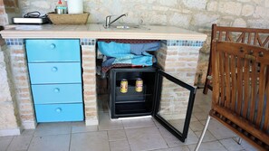 A kitchen with a built-in oven, a sink, and a blue cabinet.