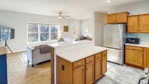 A modern kitchen with wooden cabinets, a stainless steel refrigerator, and a large island. - Hike & Bike! Peaceful Wooded Retreat in Old Fort (Old Fort)