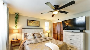 A bedroom with a bed, nightstands, a ceiling fan, a TV, and a framed 'HOME' sign. - Pet Friendly, Private! Multi-level Brookline Home (Pittsburgh)