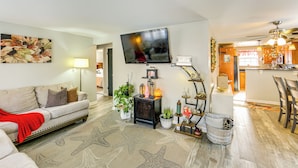 A living room with a sofa, starfish rug, and a TV. There is a kitchen in the background. - Pet Friendly, Private! Multi-level Brookline Home (Pittsburgh)
