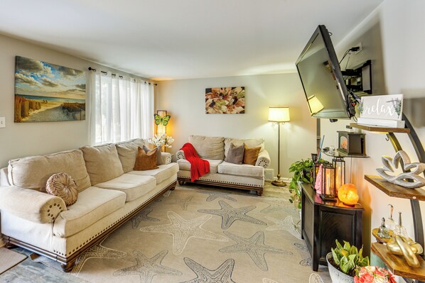 A living room with a beige sofa, a smaller sofa, a star-patterned rug, a flat-screen TV, and a small table with decorative items. - Pet Friendly, Private! Multi-level Brookline Home (Pittsburgh)