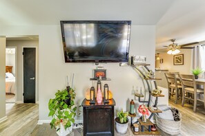 A living room with a flat-screen TV mounted on the wall, a wooden coffee table, a dining area with a table and chairs, and a ceiling fan. - Pet Friendly, Private! Multi-level Brookline Home (Pittsburgh)