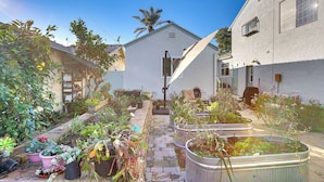 A garden with potted plants and a pathway leading to a house. - Couples Retreat in Lompoc! Studio w/ Lush Garden (Lompoc)