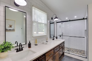 A modern bathroom with a double sink, a large mirror, a shower area, and a potted plant. - Hike & Fish! Tyler Family Home 11 Mi to State Park (Tyler)