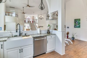 Una cocina amplia con armarios blancos, lavavajillas y una isla grande.