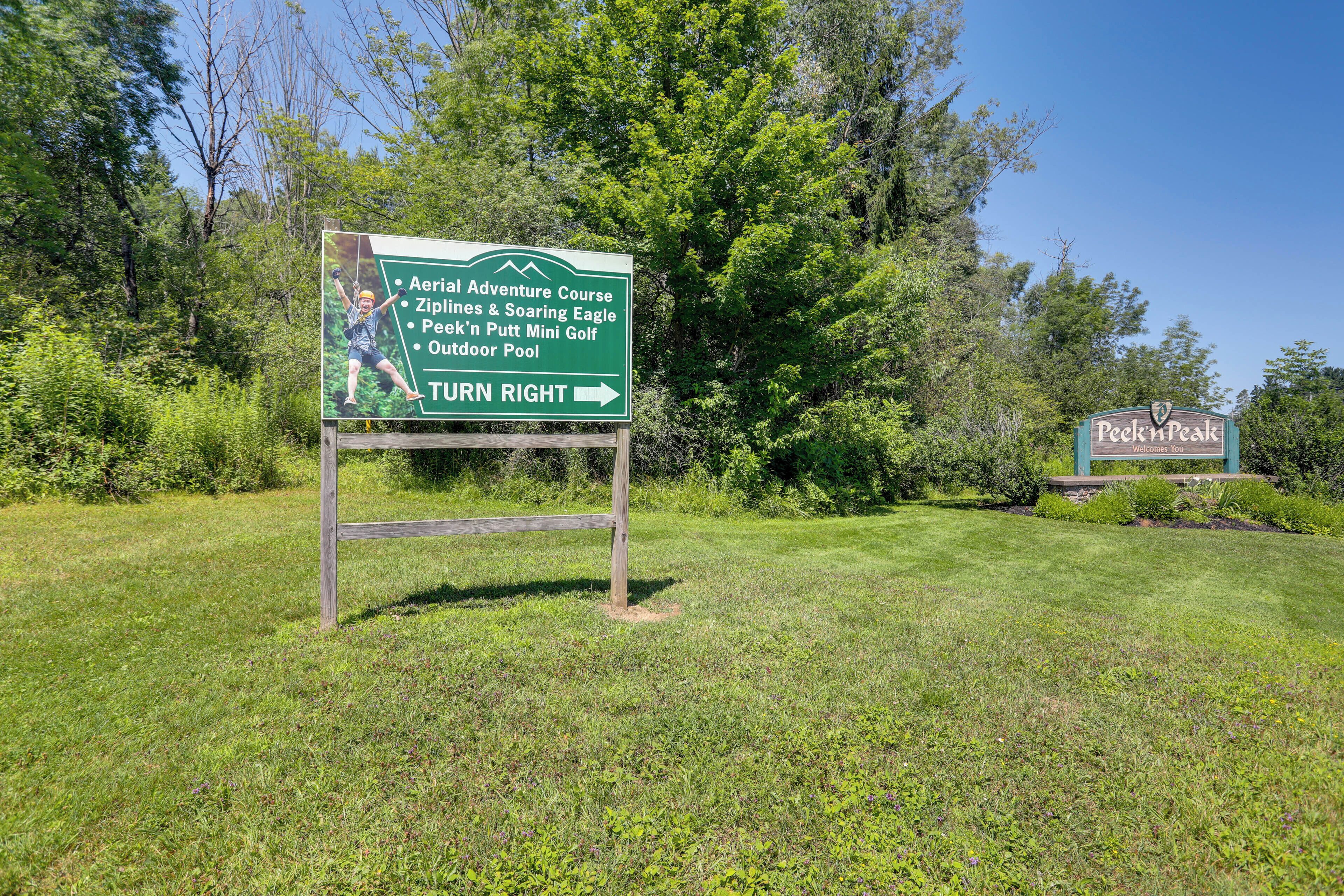 A signboard listing amenities like an aerial adventure course, zip lines, a mini golf, and an outdoor pool.