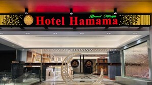 The entrance of Hotel Hamama with a modern design, featuring a red carpet, a decorative arch, and a glass facade. - Grand Khalifa Hotel Hamama (Sylhet)