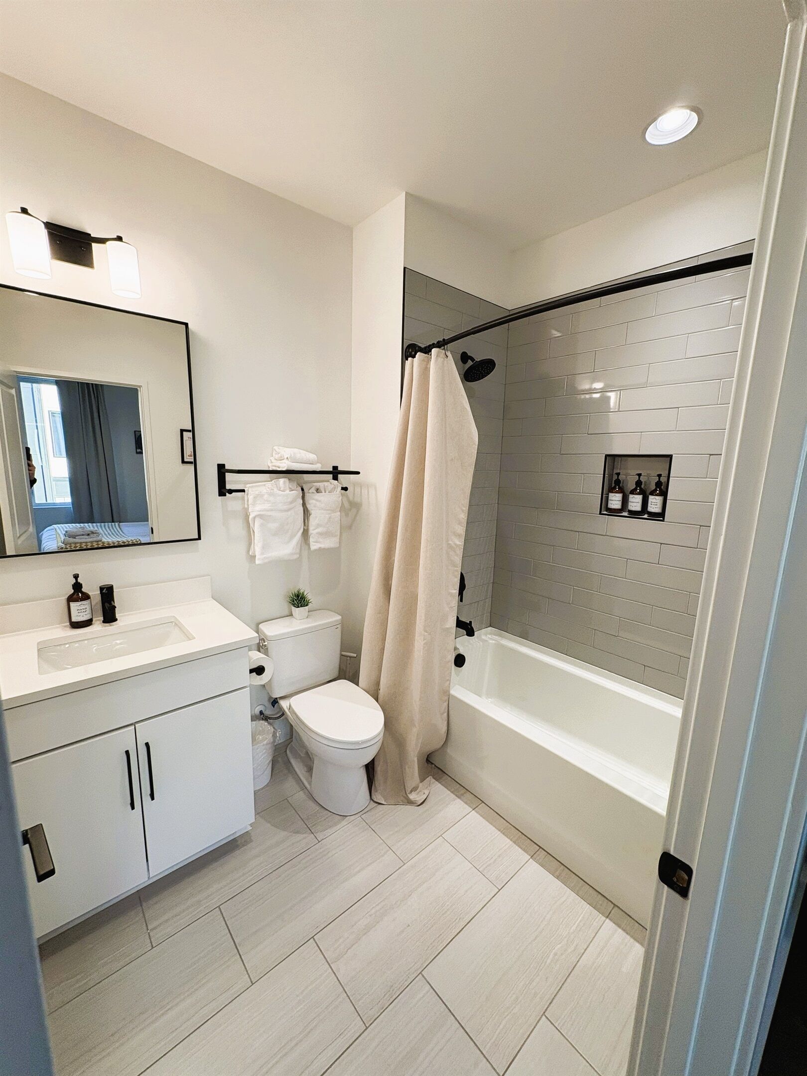 A modern bathroom with a white sink, toilet, and bathtub.