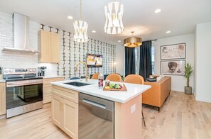A modern kitchen with a central island, stainless steel appliances, and pendant lighting. - 2 Side-by-Side Houses +Rooftop Hot Tub (Sleeps 20) (Nashville)