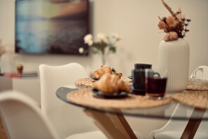 A dining table with croissants, a coffee pot, and a glass of dark liquid, likely coffee or tea. - Beatrice Manor (Termini Imerese)