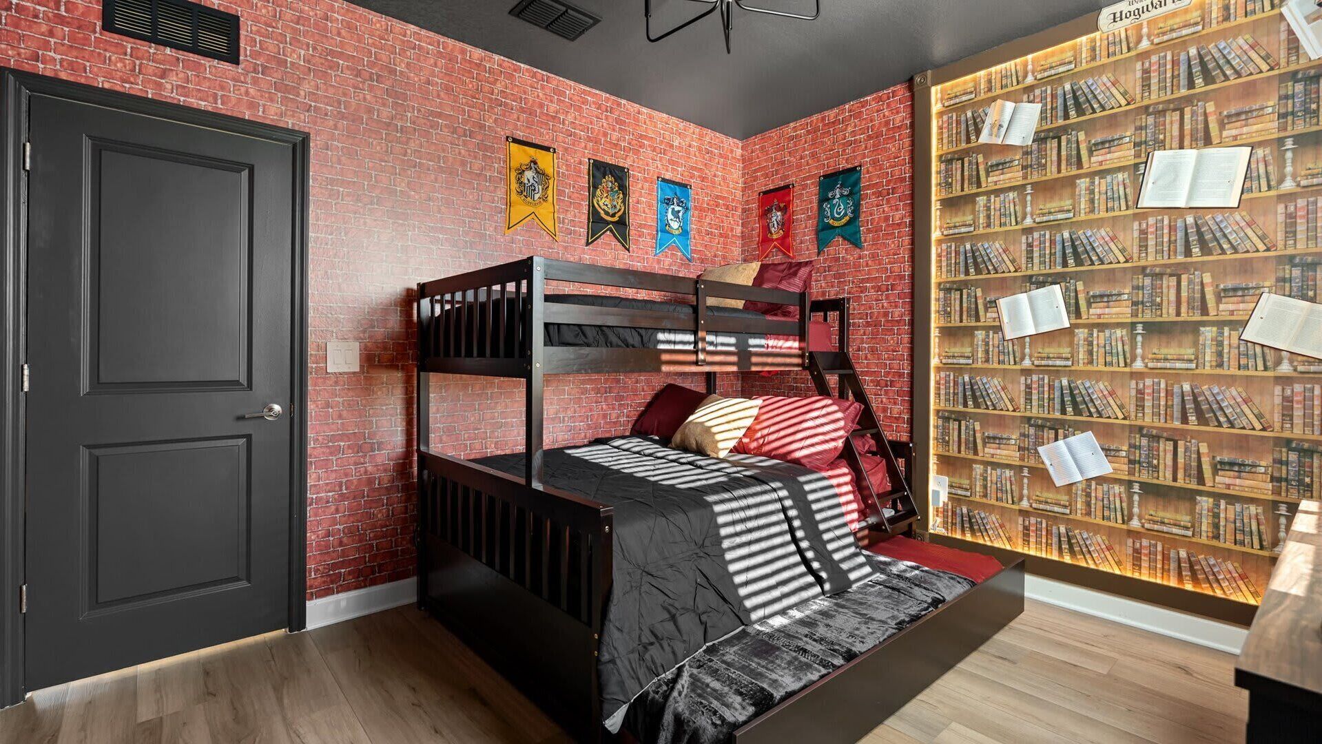 Una habitación con literas, una estantería y una puerta.