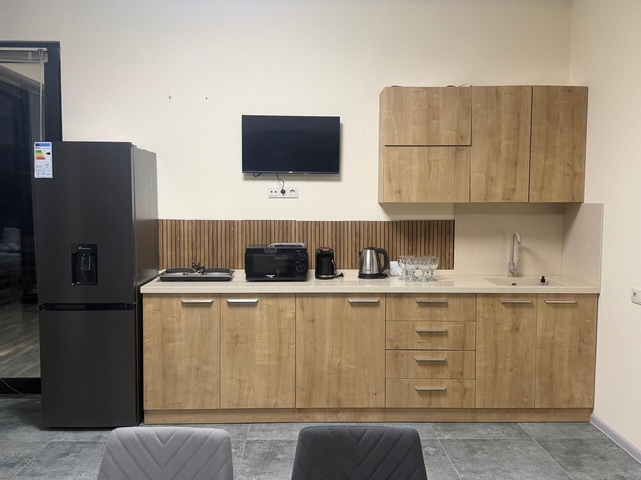 A compact kitchen with a refrigerator, microwave, toaster, and coffee maker.
