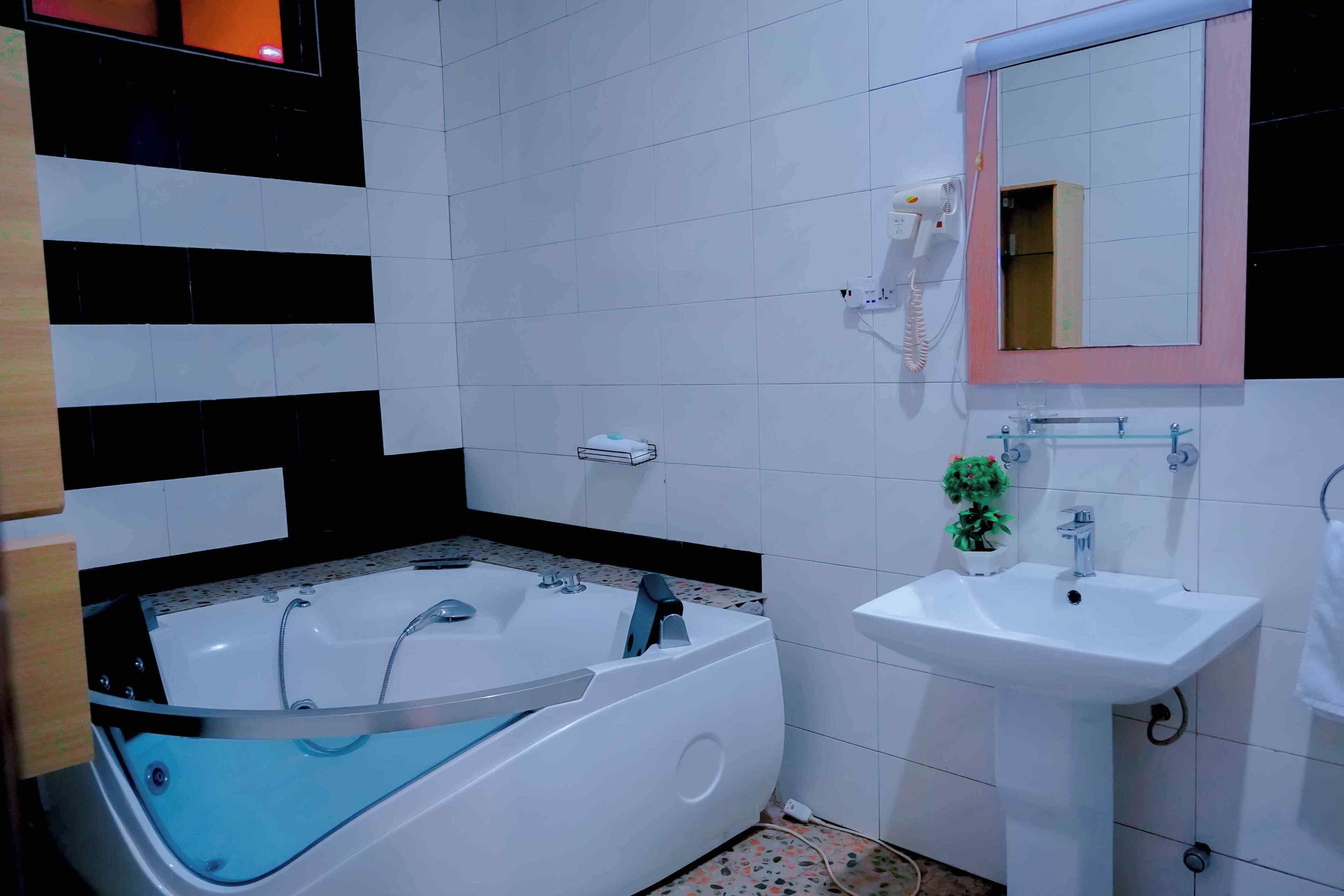 A bathroom with a bathtub, a sink, and a mirror.
