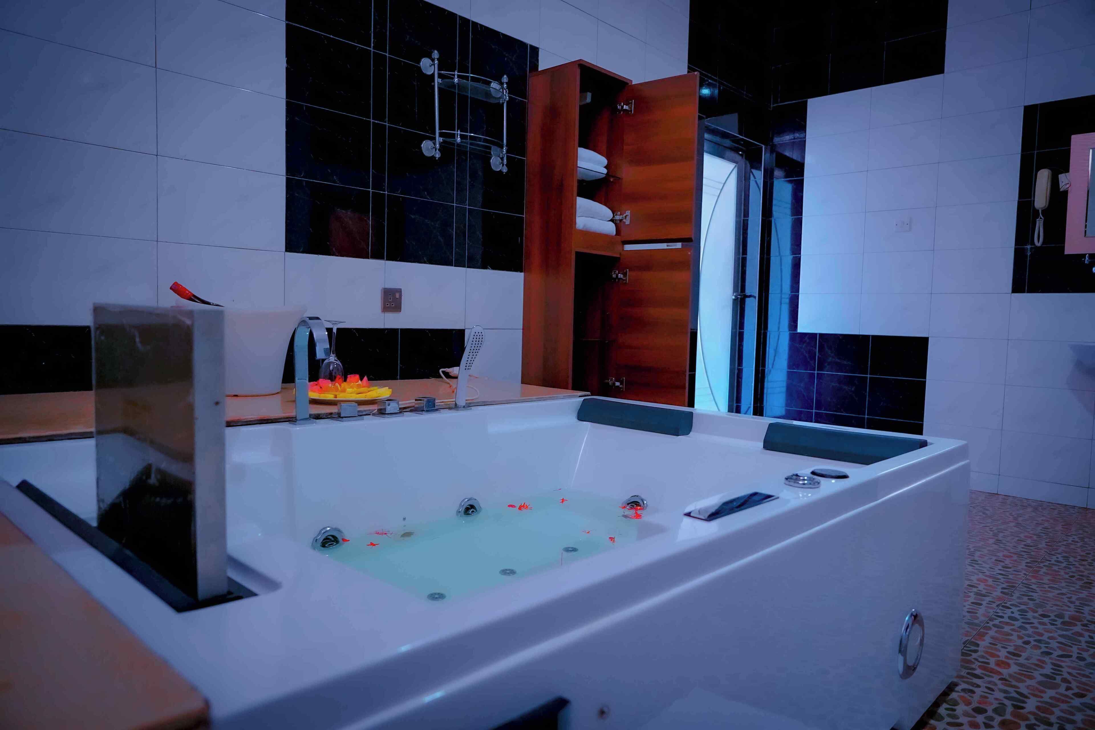 Een moderne badkamer met een groot bad, een houten wastafelmeubel en een douchehoek.