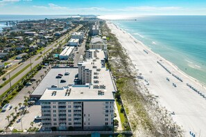 A coastal hotel with multiple floors, a parking lot, and a beach view. - Island Princess 607 3 Bedroom Condo (Fort Walton Beach)