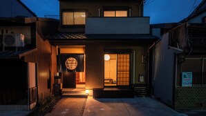 A traditional Japanese house with a wooden exterior, a sliding door, and a small porch area. - Private Residence Kyoto Station North (Kyoto)